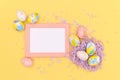 Flat lay image composition of Easter eggs, confetti on trendy yellow background. Minimal design mockup of greeting card