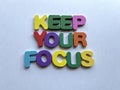 Keep Your Focus - Message with Colorful Letter Magnets on a Plain Background Royalty Free Stock Photo