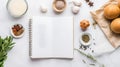 A flat lay image of an open blank recipe book surrounded by various ingredients and spices on a white marble countertop Royalty Free Stock Photo