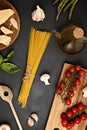 Flat lay of Ingredients for cooking italian pasta. Spaghetti, tomatoes, oil, garlic, parmezan. Top view of traditional italian cus Royalty Free Stock Photo