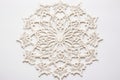 flat lay of a intricate lace doily on white background