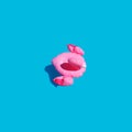 Flat lay of isolated in the center of an inflatable toy pink flamingo with a shadow on a blue azure background. Summer concept for