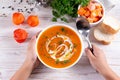 Flat-lay of kids hands and warming pumpkin cream soup with croutons on white wooden background, top view. Autumn vegetarian, vegan Royalty Free Stock Photo