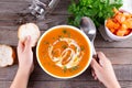 Flat-lay of kids hands and warming pumpkin cream soup with croutons on wooden background, top view. Autumn vegetarian, vegan, Royalty Free Stock Photo