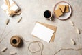 Flat lay of kraft envelope and blank paper card with copy space mock up. Top view home office desk workspace decorated with dry Royalty Free Stock Photo