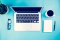 Flat lay of laptop computer and plant and cup of coffee on desk in office, workplace and notebook and glasses and potted tree. Royalty Free Stock Photo