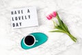 Flat lay with lightbox with text Have a lovely day and coffee cup. Social media, motivation quote, feminine blog, morning of