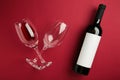 Flat lay of lying red wine bottle with glasses for tasting on dark red background Royalty Free Stock Photo