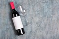 Flat lay of lying red wine bottle with white empty label and glass for tasting Royalty Free Stock Photo