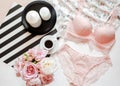 Flat lay. Top view pink lace lingerie. Beauty blog. Bouquet of roses and pions, parfume, jewelry, coffee on white bed background