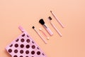 Flat lay makeup brushes and cosmetic bag on a soft pink background. View from above, copy space. Female fashionable creative