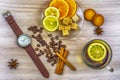 Flat lay. Men`s watches with leather strap. Slices of lemon and orange on a saucer. Cup of tea with lemon. Coffee beans, cookies