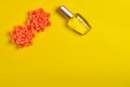 Flat lay minimalism of a perfume bottle and candles in the form of flowers on a yellow background