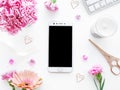 Flat lay mobile phone mockup with pink cardnation flowers, computer keyboard, white candle and rose gold scissor on white table Royalty Free Stock Photo