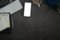 Flat lay mock up mobile phone with blank screen, laptop, notepad and coffee cup on black stone background Royalty Free Stock Photo