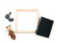 Flat lay mock up, top view, wooden frame, toy squirrel, stones, black note pad. Interior layout, square poster mockup, wood frame Royalty Free Stock Photo