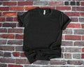 Flat lay mockup of charcoal gray tshirt on brick background Royalty Free Stock Photo