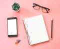 Flat lay mockup design of workspace desk with blank notebook, smartphone, stationery on pink pastel color with copy space Royalty Free Stock Photo