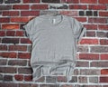 Flat lay mockup of gray tee shirt on brick background Royalty Free Stock Photo