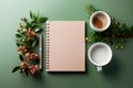 Flat lay mockup notebook with springs, a pen, a cup of coffee and milk with flowers on a green background