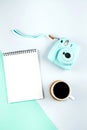 Flat lay with modern mini camera, empty notebook and cup of coffee. Fashion blogger, minimal concept Royalty Free Stock Photo