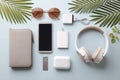 Flat lay of modern tech accessories and summer essentials on light blue background Royalty Free Stock Photo