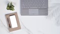 Flat lay of modern white marble office desk table with laptop, smartphone mock up, ballpoint pen, spiral notebook with little Royalty Free Stock Photo