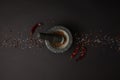 flat lay with mortar, pestle, spices and chili peppers on black tabletop Royalty Free Stock Photo