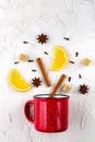 Flat lay of mulled wine ingredients. Cinnamon, orange, cardamom, clove, anise star and cup on white