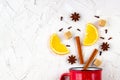 Flat lay of mulled wine ingredients. Cinnamon, orange, cardamom, clove, anise star and cup on white