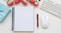Flat lay of a notebook, pen, mouse, keyboard, and gift box with pink roses image photo Royalty Free Stock Photo