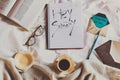 Flat lay of a notebook with a text \'Hey Sunday\', a coffee mug, book, and envelopes