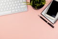 Flat lay office desk with computer keyboard, smart phone, pen, note pad and potted plant Royalty Free Stock Photo