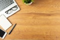 Flat lay of Office desk with laptop, and blank notepad with a coffee cup and smart phone on wood table Royalty Free Stock Photo