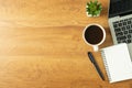 Flat lay of Office desk with laptop, and blank notepad with a coffee cup on wood table Royalty Free Stock Photo