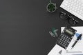 Flat lay office desktop work space of wireless keyboard, report graph and charts, pen, calculator and Glasses on black desk table Royalty Free Stock Photo