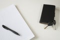 Lined paper with black pen, keys and smartphone, on white desk. Space for text. Royalty Free Stock Photo