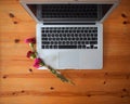 Flat lay of an office table with a laptop and flowers