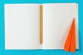 Flat lay open notebook pencil paper airplane blue background Top Royalty Free Stock Photo