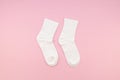 Flat lay Pair of white cotton socks on a pastel pink background. Top view children`s socks Royalty Free Stock Photo