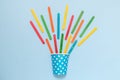 Paper cup and multicolored ice cream sticks on blue background minimalistic concept Royalty Free Stock Photo