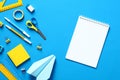 Flat lay paper notepad with school or office supplies on blue desk table. Back to school concept. Top view. Copy space Royalty Free Stock Photo