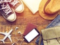 Flat lay of passport ,mobile, plane model , sneakers , wallet , camera and traveler`s accessories items