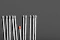 Flat lay pattern of matches with black heads and one small one with orange heads, copy space, business idea concept