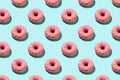 Flat lay pattern of tasty pink colorful donut on blue background Royalty Free Stock Photo