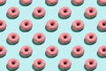 Flat lay pattern of tasty pink colorful donut on blue background
