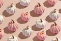 Flat lay pattern from white and pink decorative autumn pumpkins on beige background in hard light Royalty Free Stock Photo