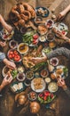 Flat-lay of peoples hands holding traditional turkish breakfast cuisine food