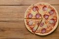 Flat lay pepperoni pizza on rustic wooden background. Pizza salami cut in slices. Fast food, junk food concept.