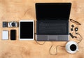 Flat lay of personal office accessories, laptop, notebook, coffee cup and camera on wood background, top view Royalty Free Stock Photo